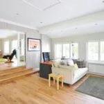 Spacious and bright modern living room with wooden floors and stylish furniture.