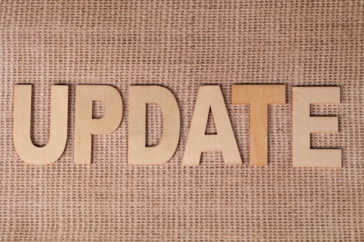 Wooden letters arranged to spell 'UPDATE' on a textured burlap surface, perfect for business or project imagery.
