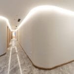 Bright modern hallway with curved walls and soft lighting, showcasing minimalist interior design.
